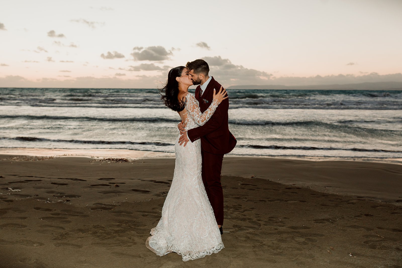 A bride and groom leaning into each other at sunset on a Cyprus beach
